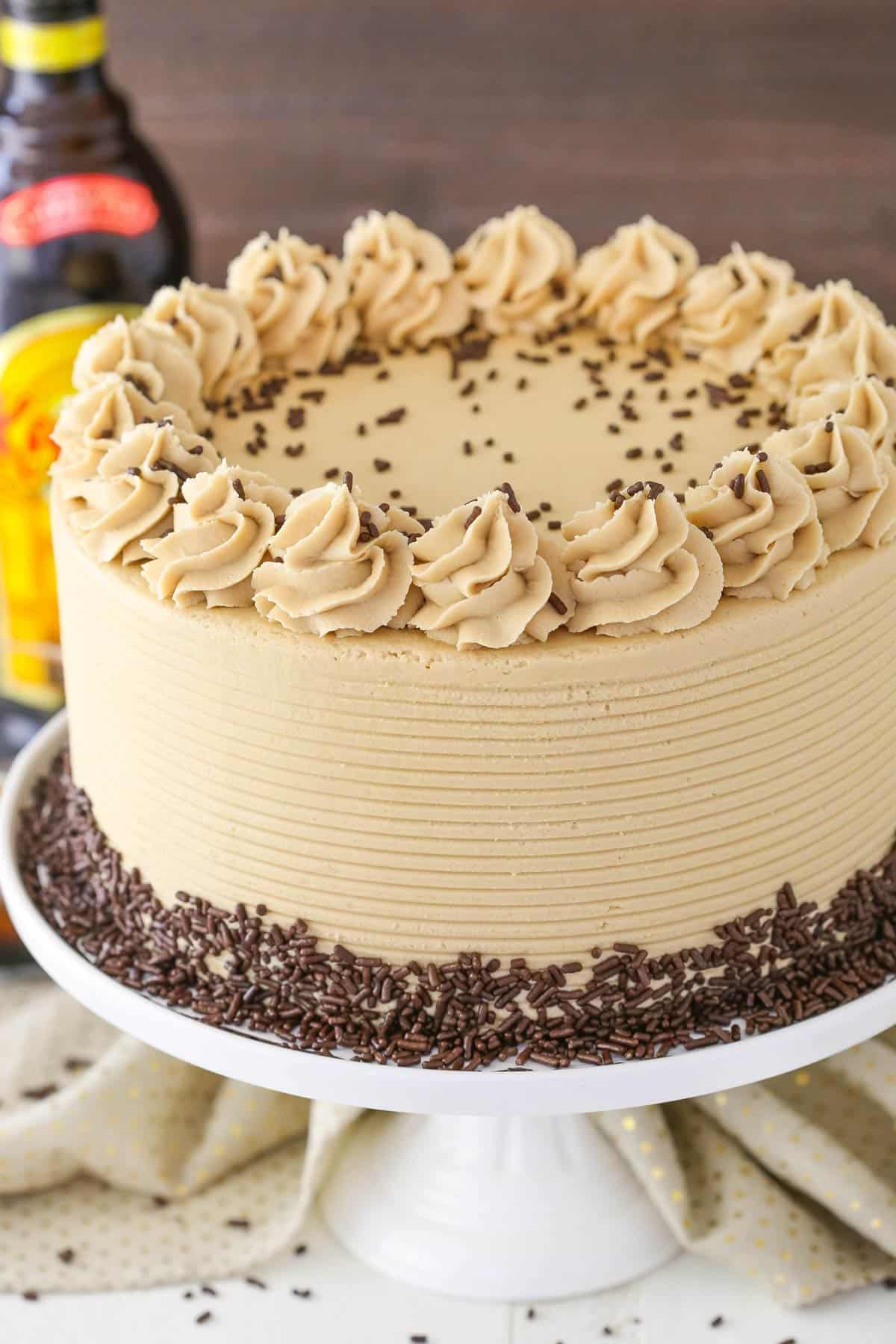 A Kahlua coffee chocolate layer cake on a white cake stand.