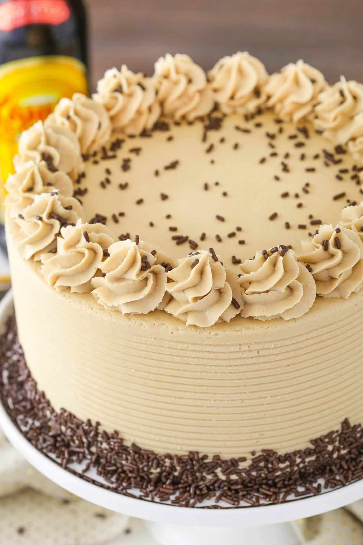 A Kahlua coffee chocolate layer cake on a white cake stand.
