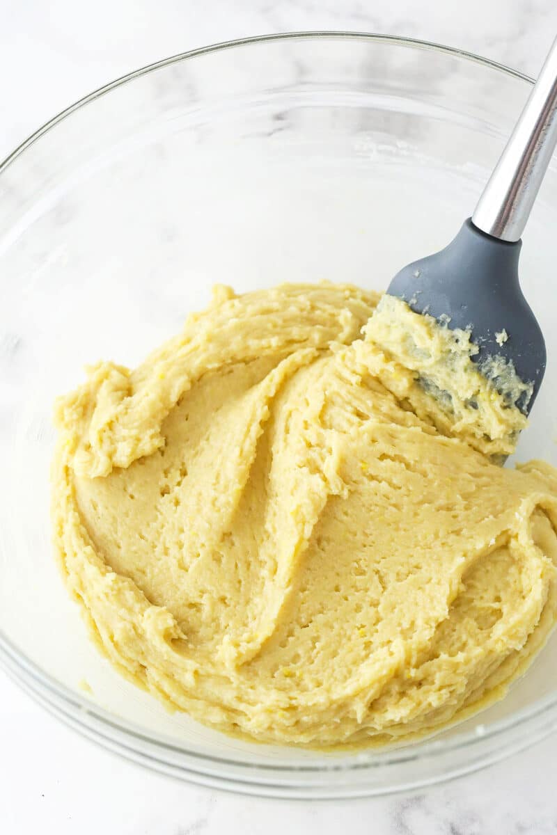 Mixing the dry ingredients for lemon crinkle cookie dough into the wet ingredients.
