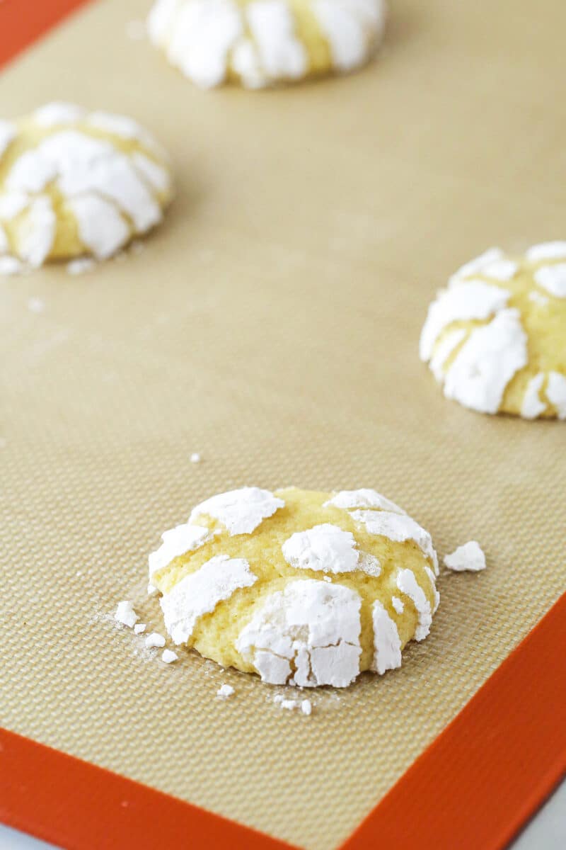 Lemon crinkle cookies cooling on a baking sheet.