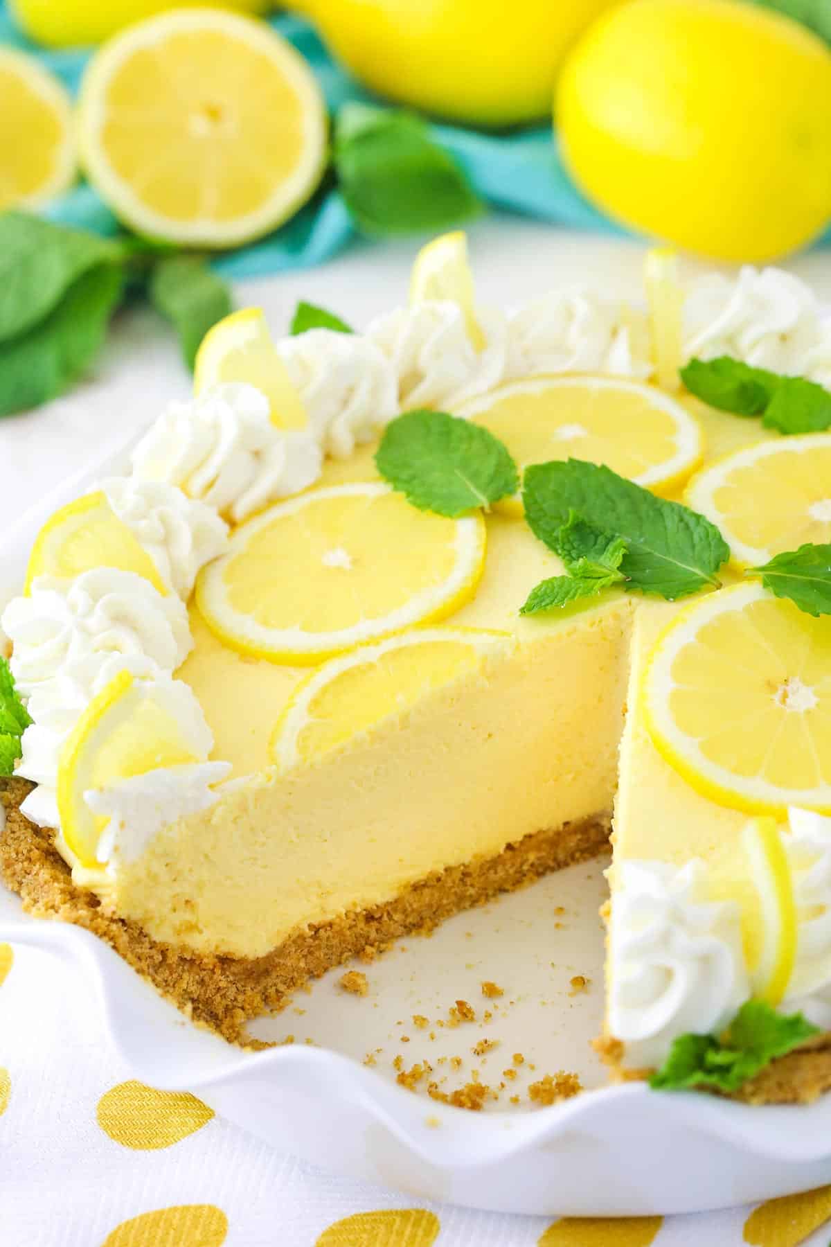A lemon mascarpone cream pie with a slice missing in a ruffled pie plate.