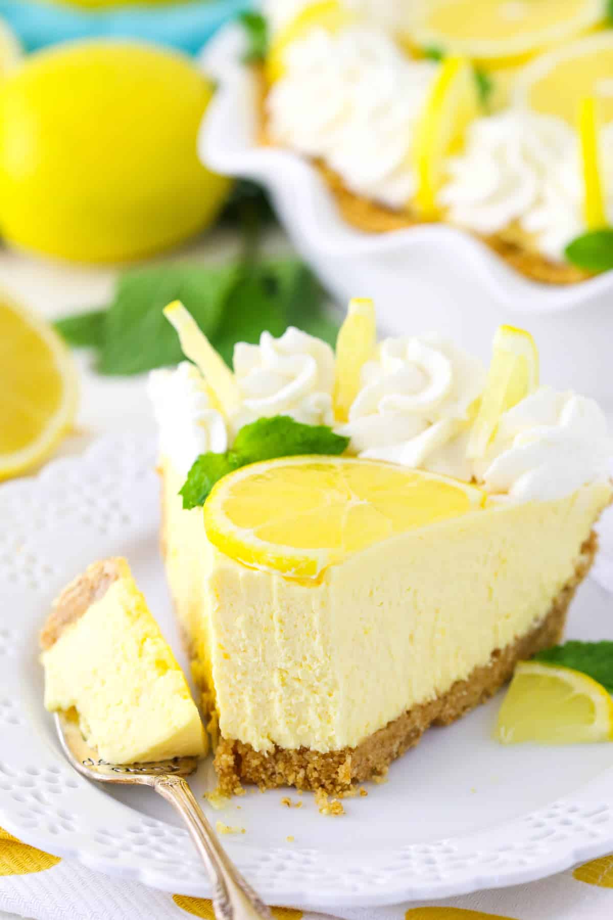 A slice of lemon mascarpone cream pie with a bite removed on a fork.