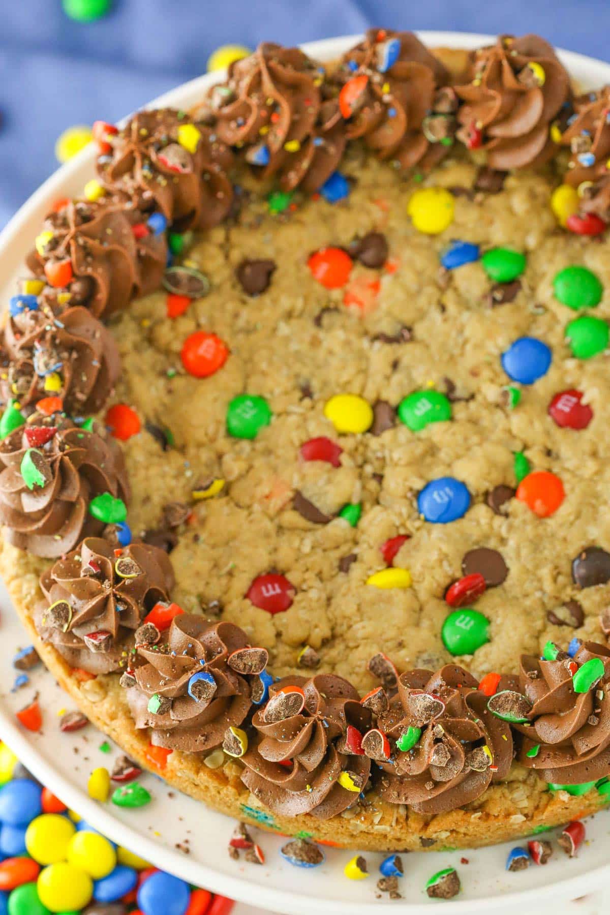 Top view of a monster cookie cake on a white plate.