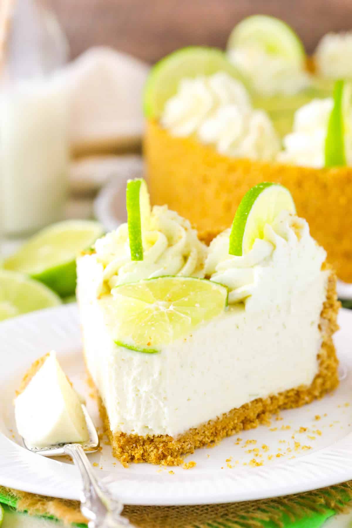 A slice of no bake key lime cheesecake with a bite removed on a fork.