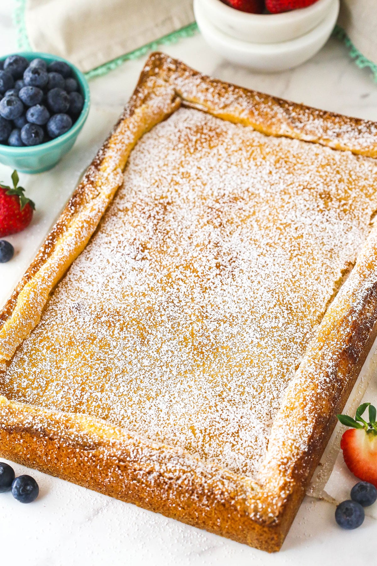 Overhead image of ooey gooey butter cake sprinkled with powdered sugar.