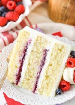 A slice of Berry Mascarpone Layer Cake on a white plate.