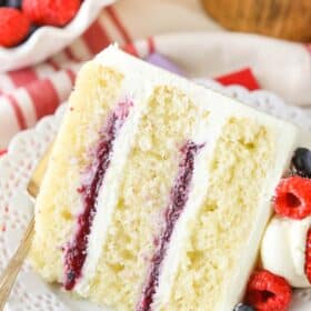 A slice of Berry Mascarpone Layer Cake on a white plate.