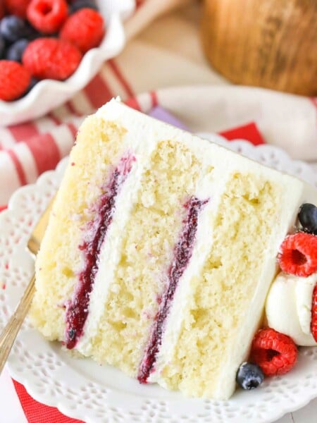 A slice of Berry Mascarpone Layer Cake on a white plate.