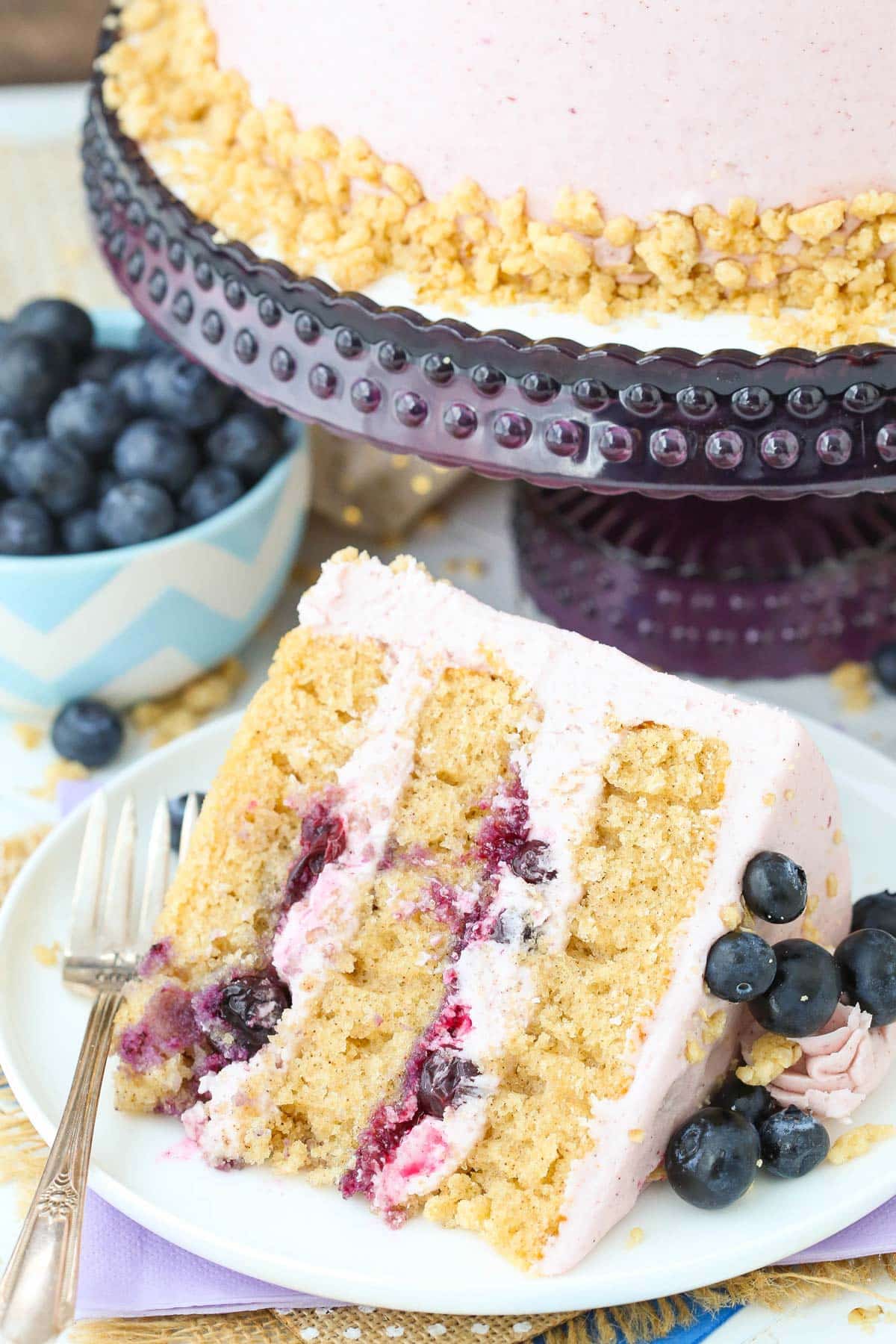 A slice of Blueberry Crumble Layer Cake on a white plate.