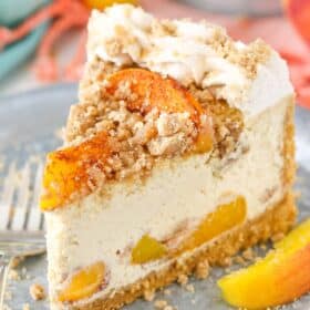 A slice of Bourbon Peach Streusel Cheesecake on a silver plate.