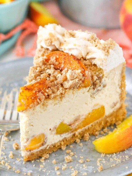 A slice of Bourbon Peach Streusel Cheesecake on a silver plate.