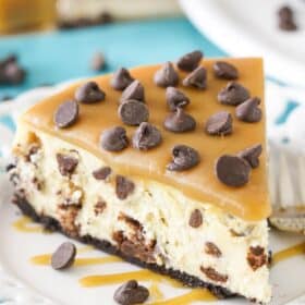 Close up of a slice of caramel chocolate chip cheesecake on a white plate.