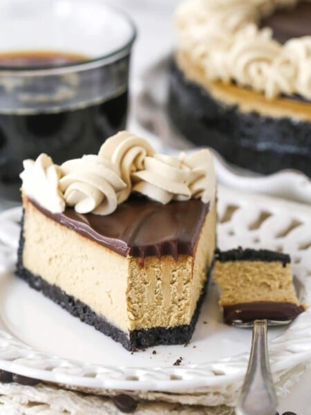 A slice of coffee cheesecake on a plate with a bite taken out of it.