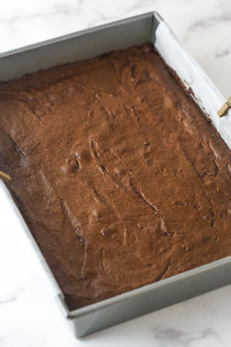 These nostalgia-filled, from-scratch Cosmic Brownies feature a fudgy brownie base topped with silky ganache and colorful sprinkles. Cosmic brownies cooling in the pan before adding chocolate ganache.