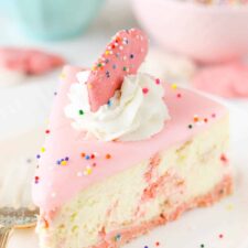 A slice of frosted animal cookie cheesecake on a white plate.