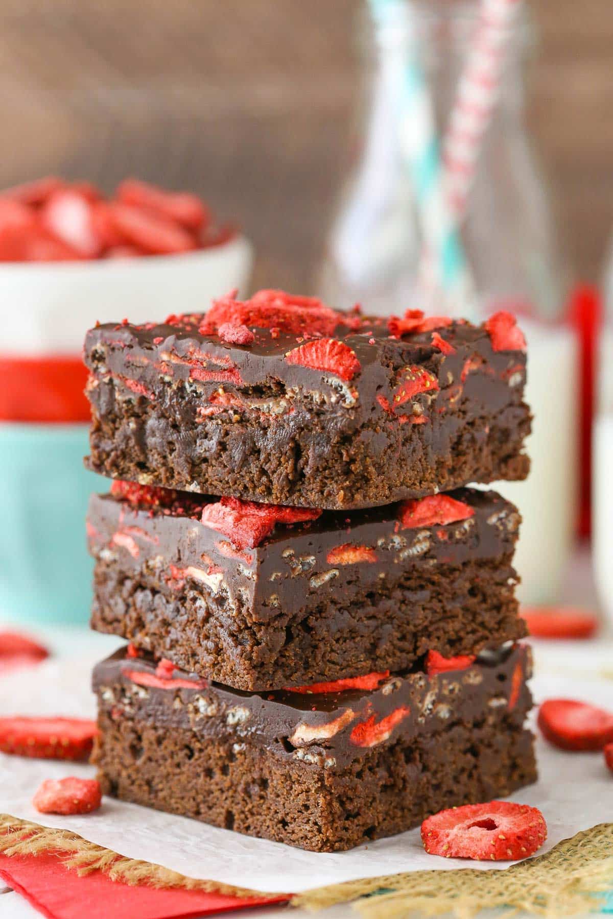Three fudgy strawberry brownies stacked one on top of the other.