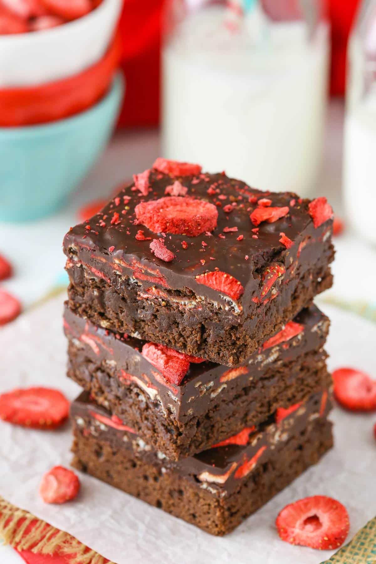 Three fudgy strawberry brownies stacked one on top of the other.