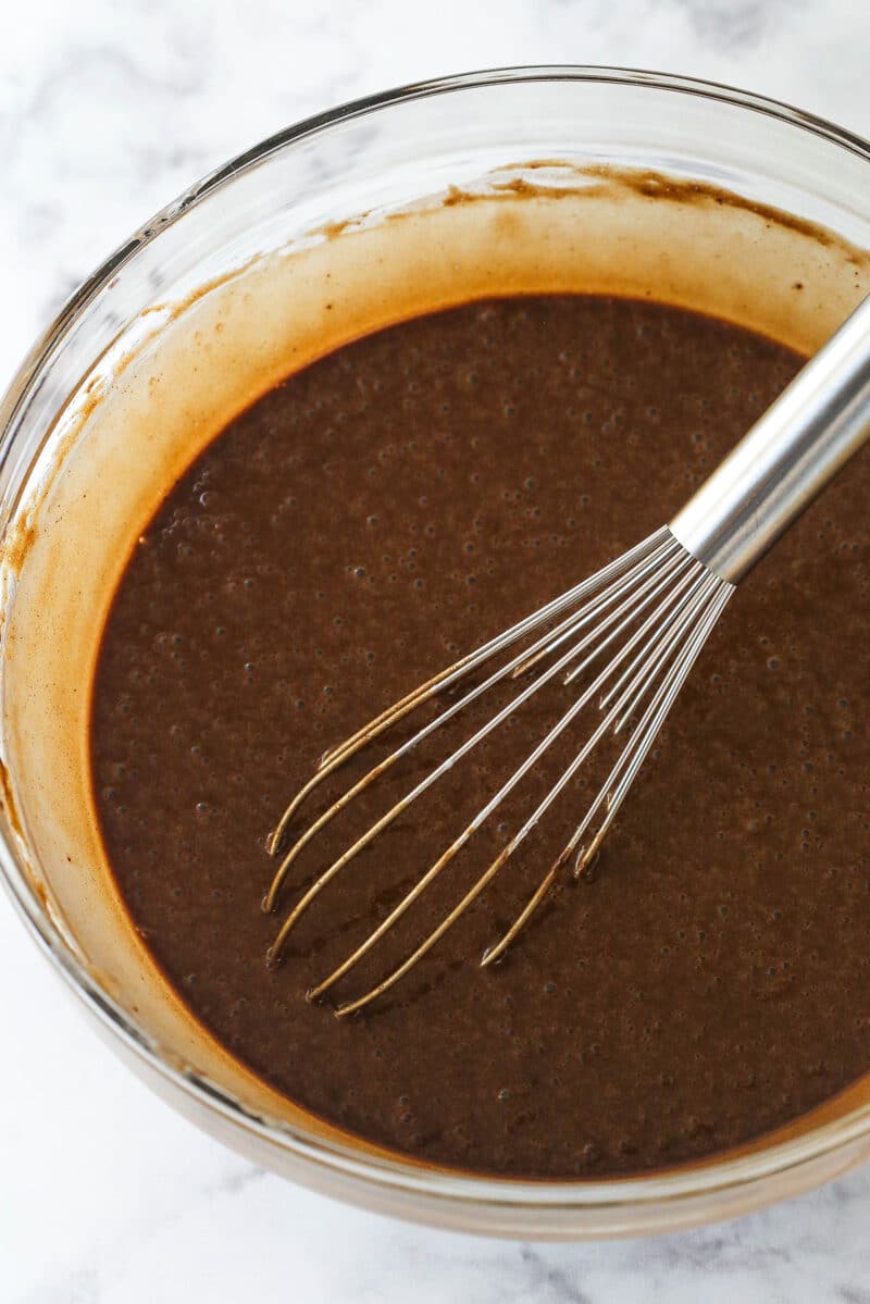 Mixing the dry ingredients into the wet ingredients for chocolate cupcakes.