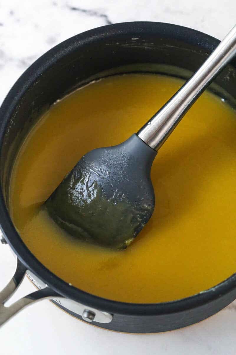 Cooking egg yolks, evaporated milk, vanilla, sugar, and butter in a saucepan.