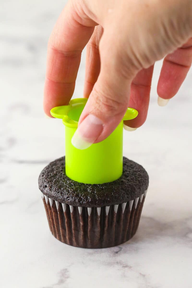 Coring a cored chocolate cupcake with a cupcake corer.
