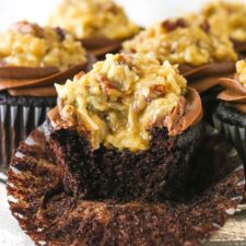 A German chocolate cupcake with a bite taken out of it.