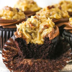 A German chocolate cupcake with a bite taken out of it.