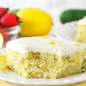A piece of lemon zucchini cake with a bite taken out of it.