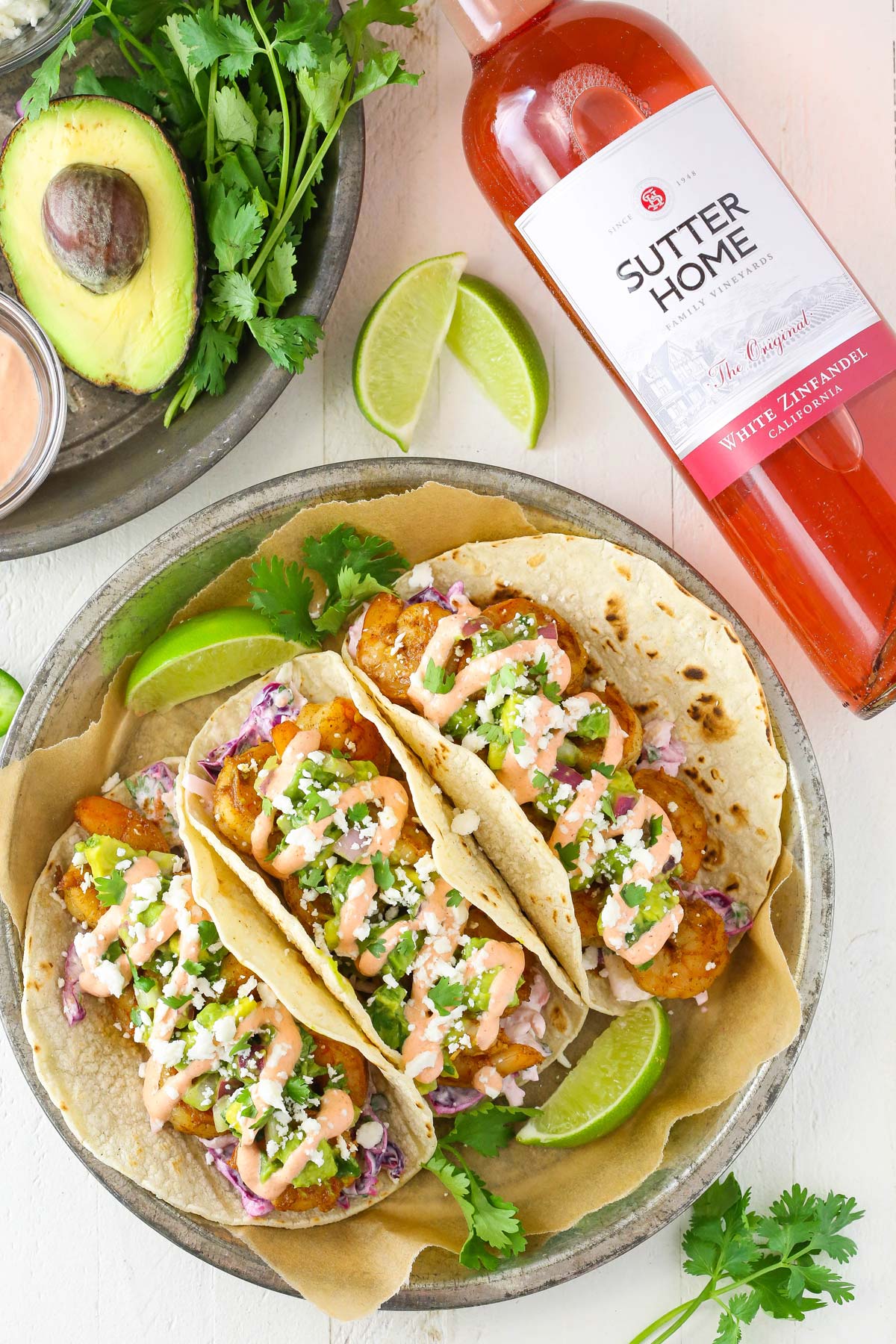 Three spicy sriracha shrimp tacos on a plate.