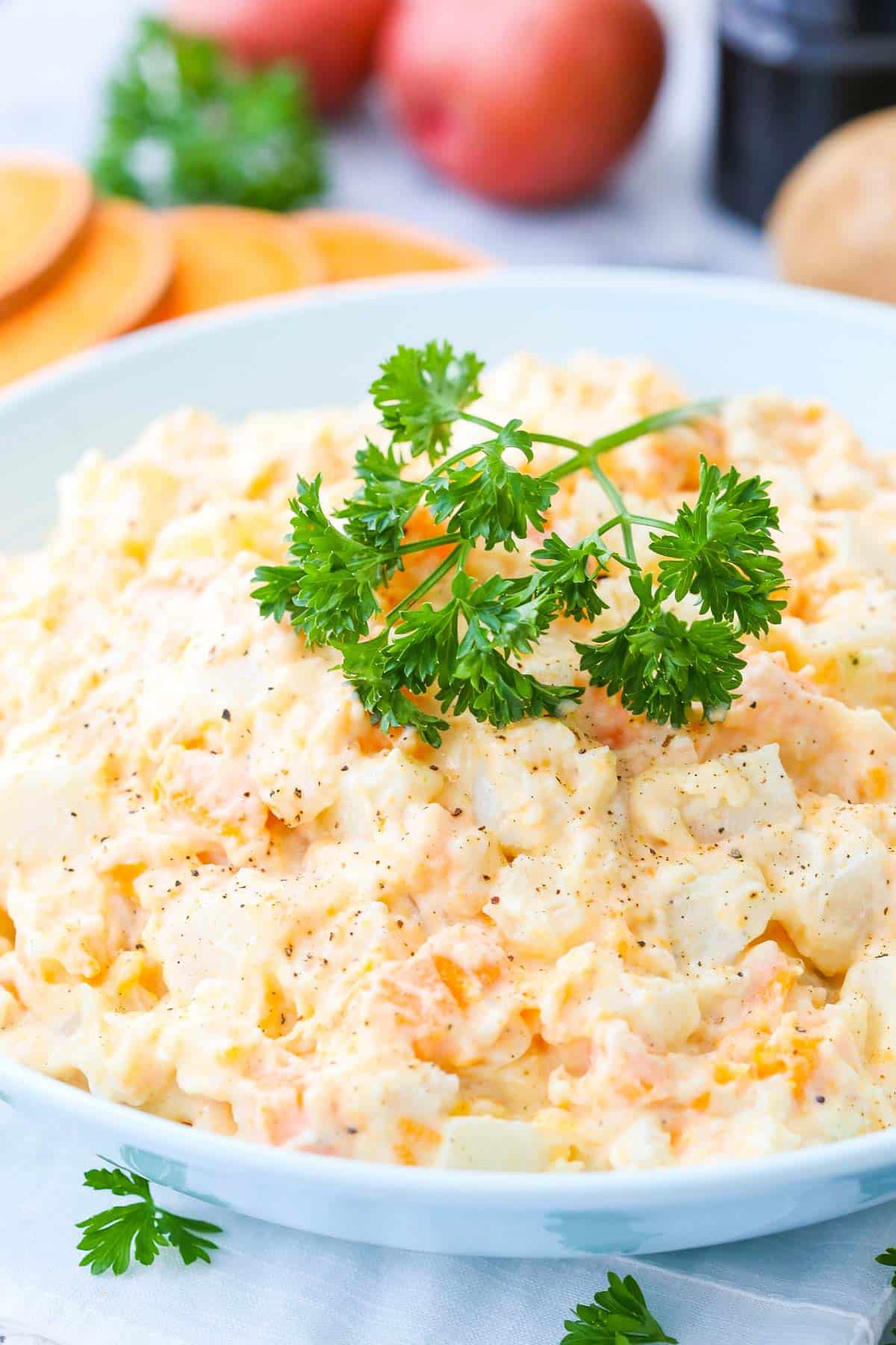 A bowl of three potato salad with parsley on top.