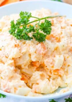 Close up of a bowl of three potato salad with parsley on top.