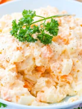 Close up of a bowl of three potato salad with parsley on top.