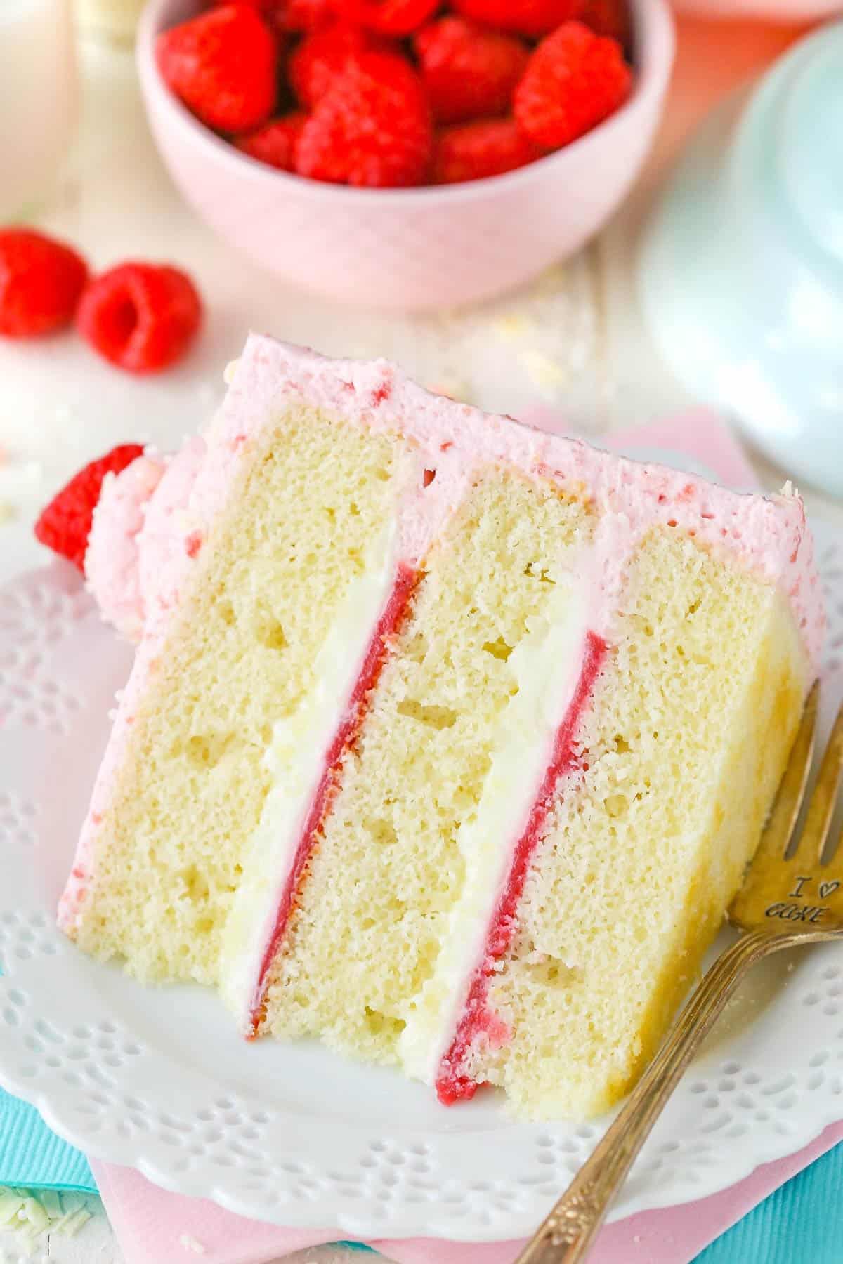 A slice of white chocolate raspberry mousse cake on a white plate.