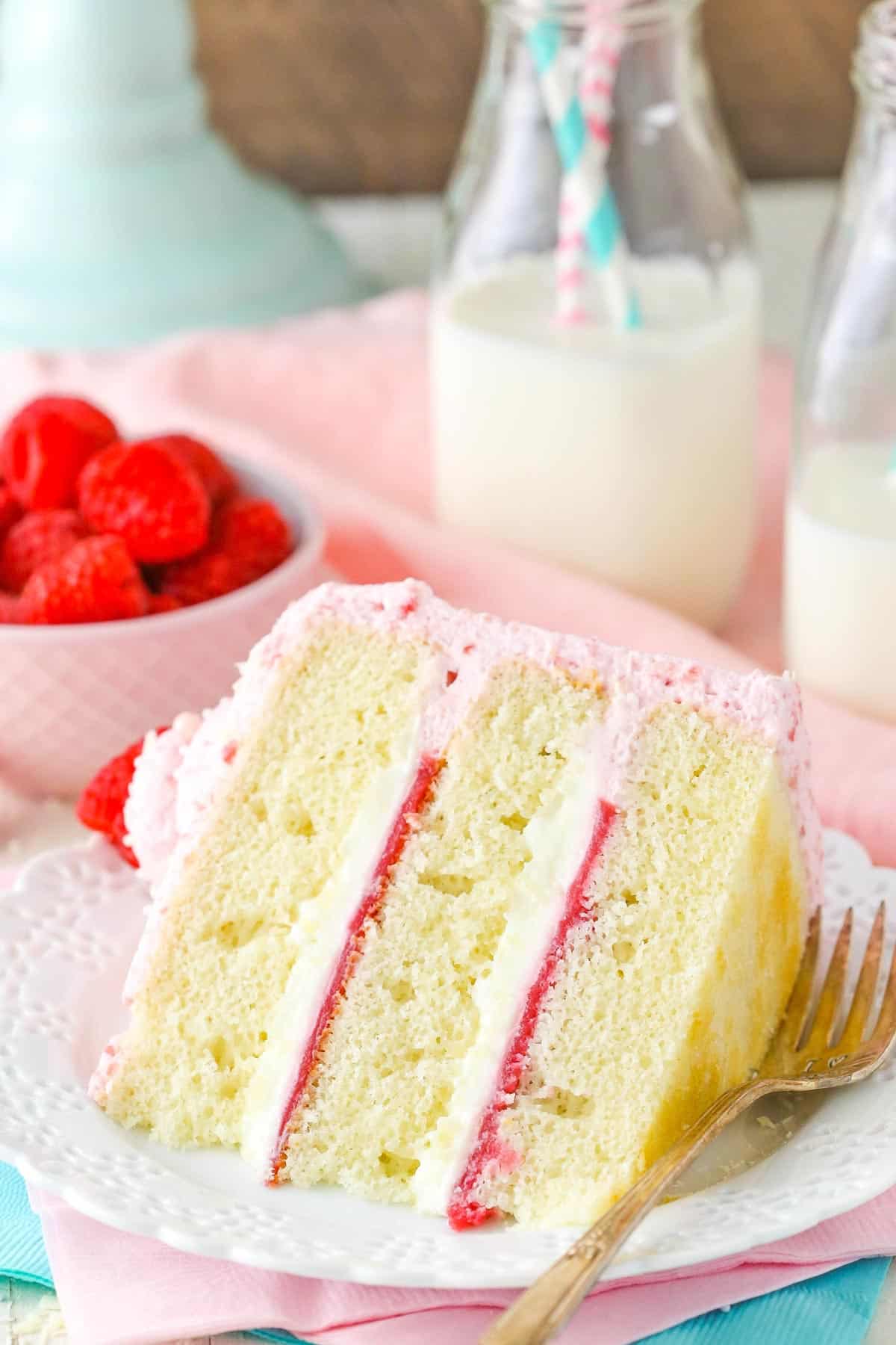 A slice of white chocolate raspberry mousse cake on a white plate.