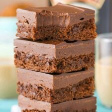 A stack of 4 Baileys fudge brownies stacked one on top of the other with a bite out of the top brownie.