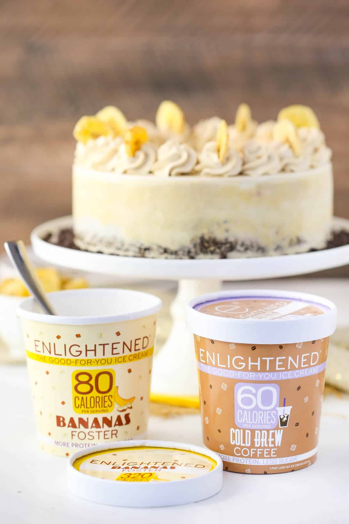 Two containers of low-calorie ice cream with a cake in the background.