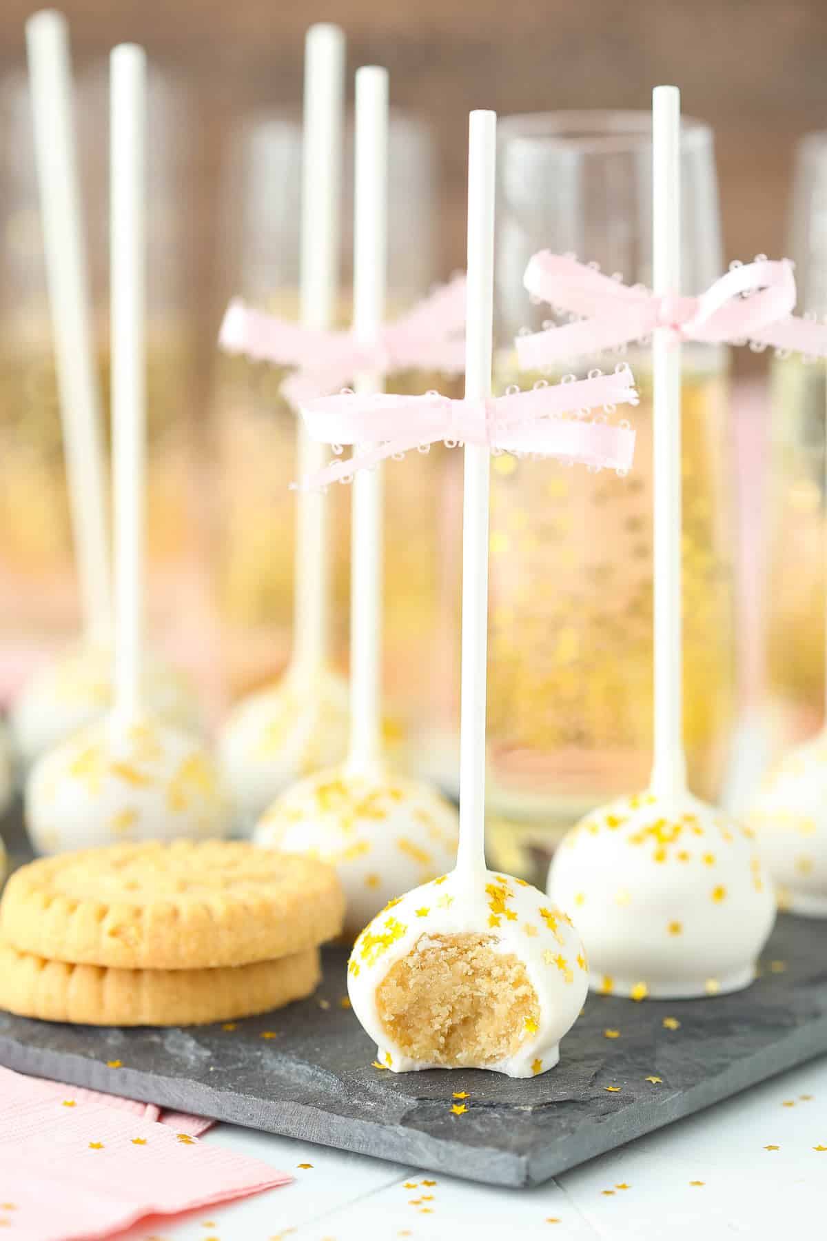 Cookie pops on a granite slab with a bite removed from front pop.