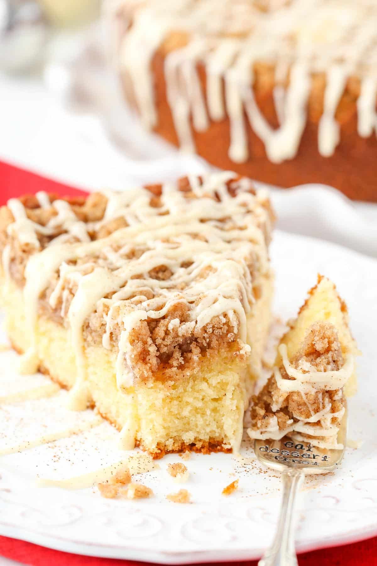A slice of eggnog crumb cake with a bite removed on a fork.