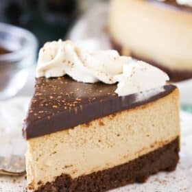 A slice of Kahlua coffee brownie cheesecake on a white plate.