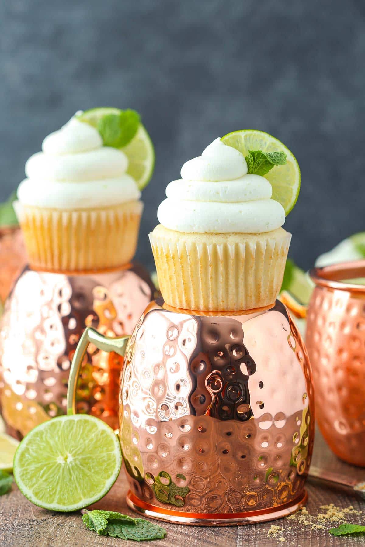 Two Moscow mule cupcakes on turned over copper cups.