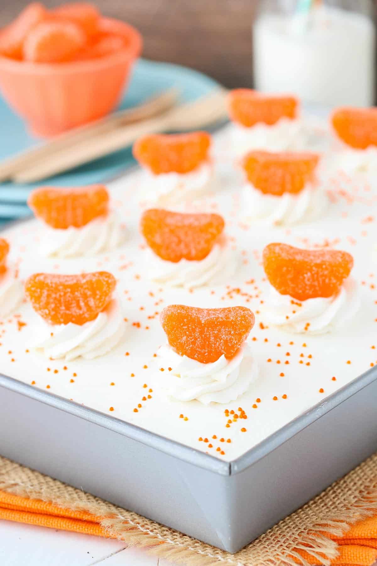 A silver cake pan filled with orange creamsicle poke cake.