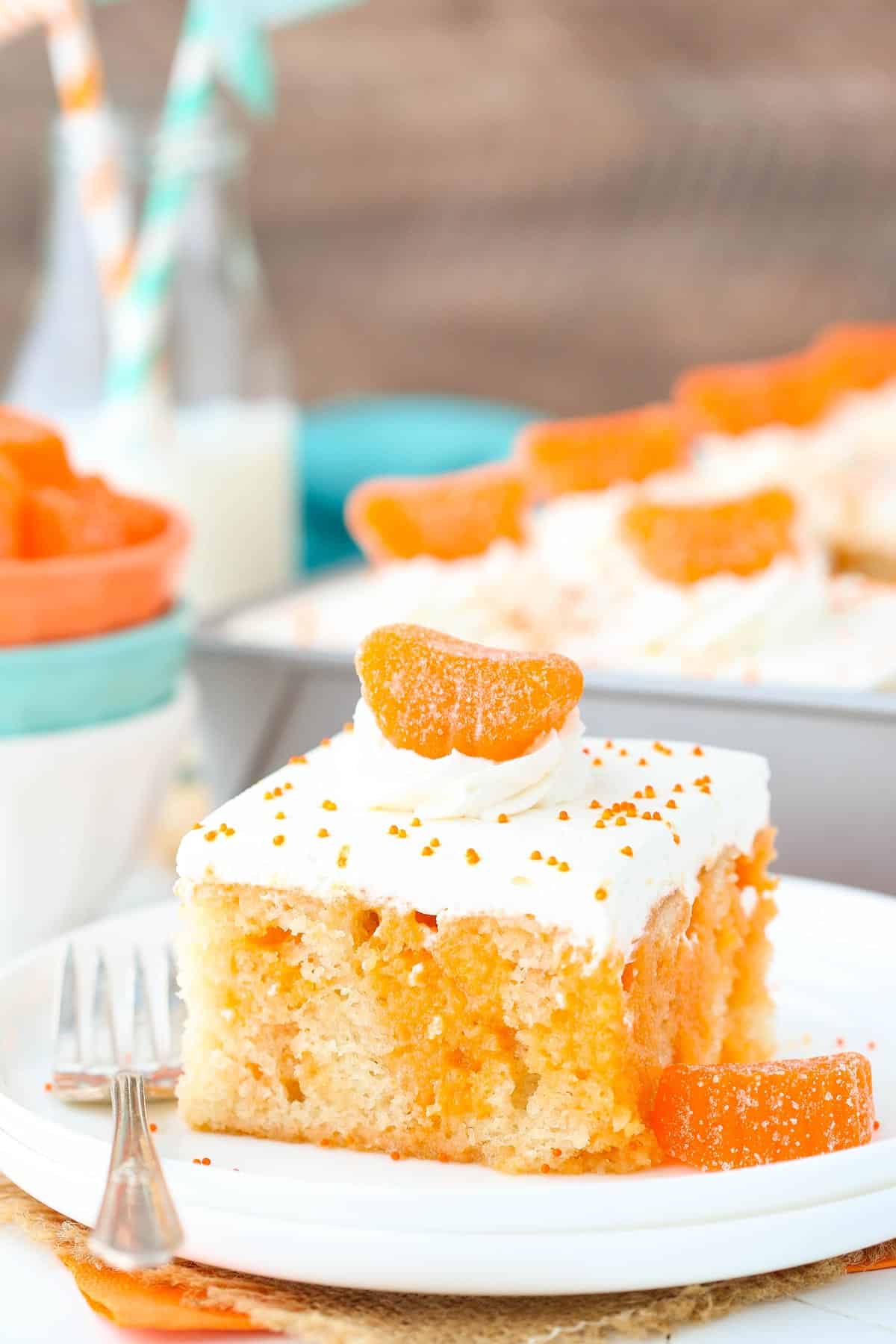 A slice of orange creamsicle poke cake on a plate.