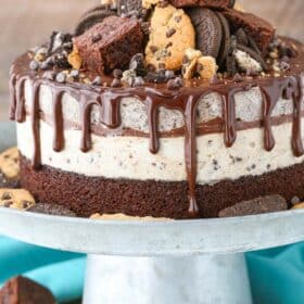 An Oreo brookie ice cream cake on a silver cake stand.