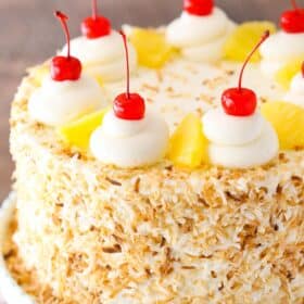 Close up of a pina colada layer cake on a cake stand.