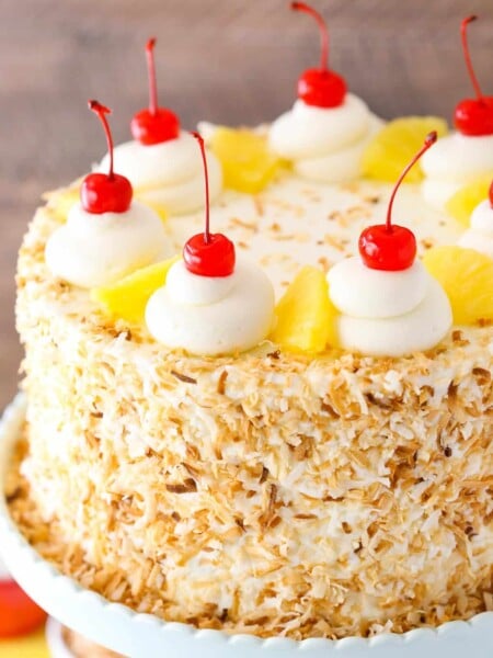 Close up of a pina colada layer cake on a cake stand.