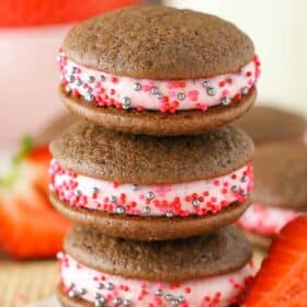 Close up of a stack of three strawberry chocolate cookie sandwiches.