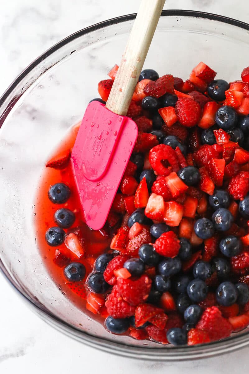 berries and berry juice in a glass bowl with a spatula