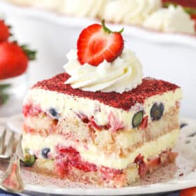 slice of berry tiramisu on white plate and blue napkin