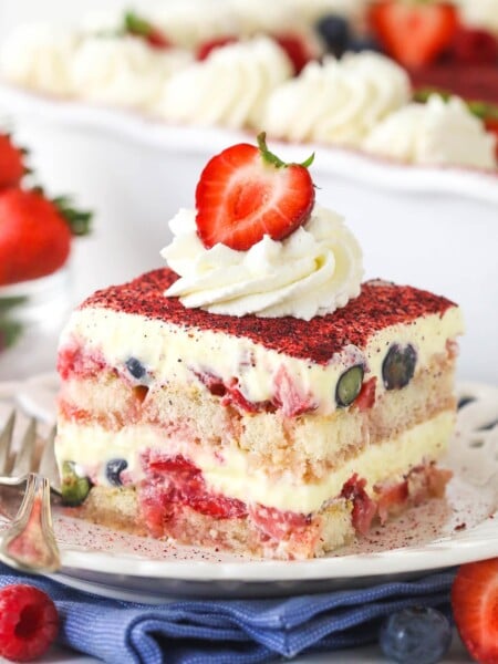 slice of berry tiramisu on white plate and blue napkin
