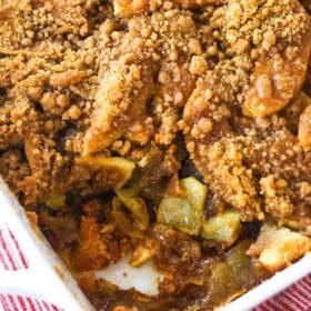 Apple brown betty in a baking dish with a serving taken from the corner.