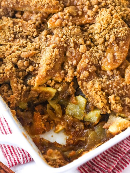 Apple brown betty in a baking dish with a serving taken from the corner.